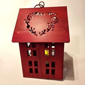 Small Red Metal Tealight House with decorative cutouts.